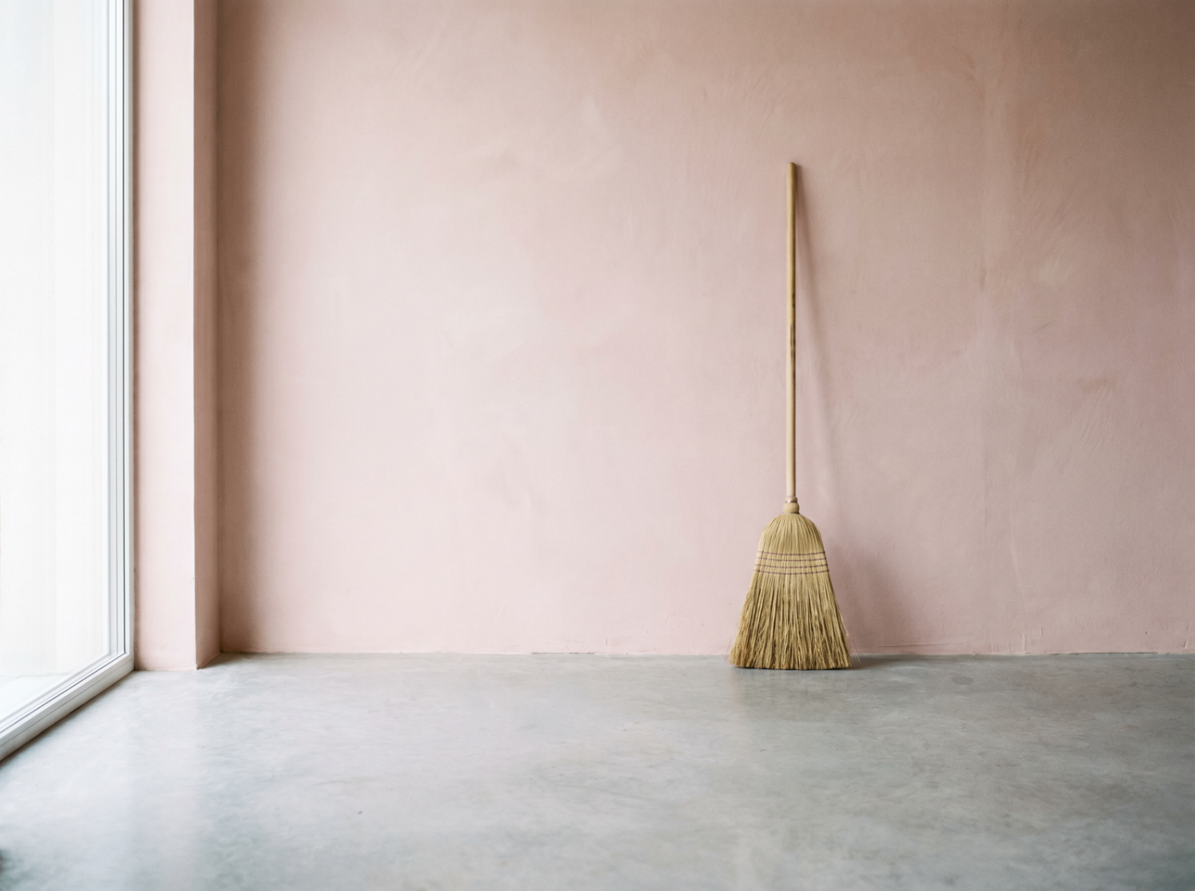 A lonely broom in a freshly cleaned pink room